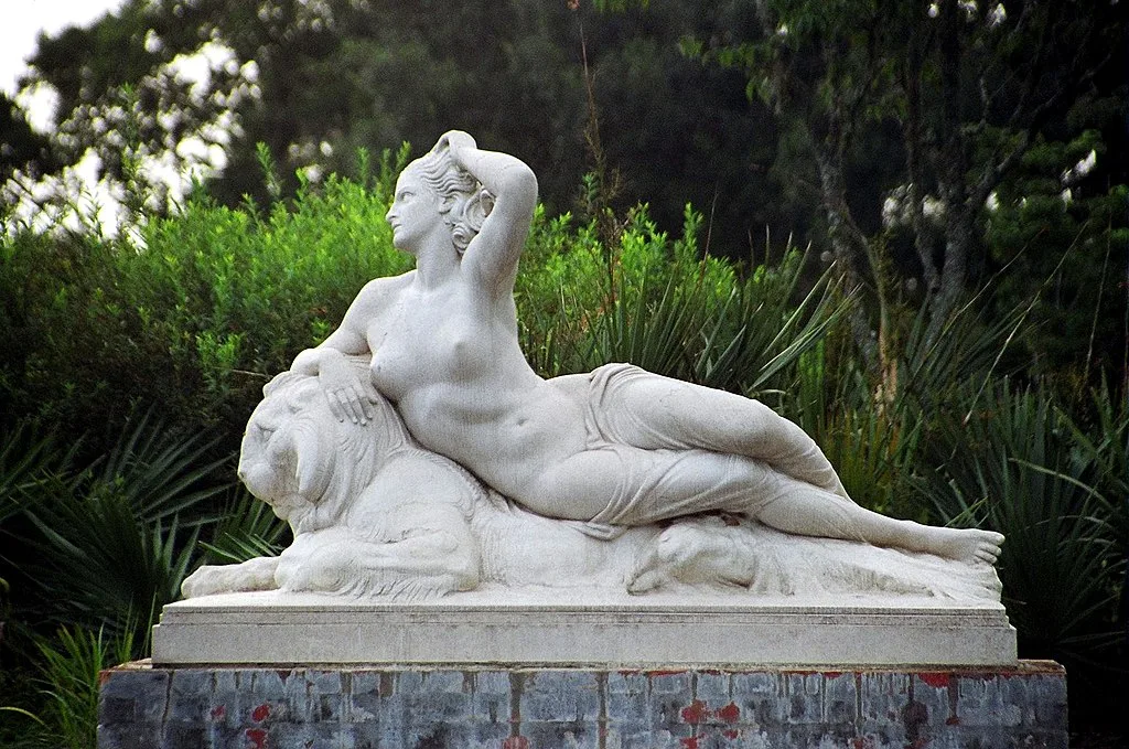 White marble statue of a woman lounging on a lion. Brookgreen Gardens, Georgetown SC
