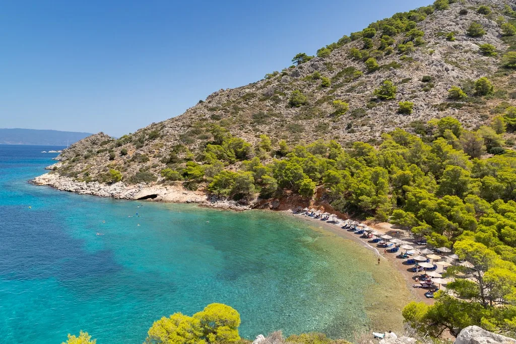 Beach on Hydra surrounded by lush forest