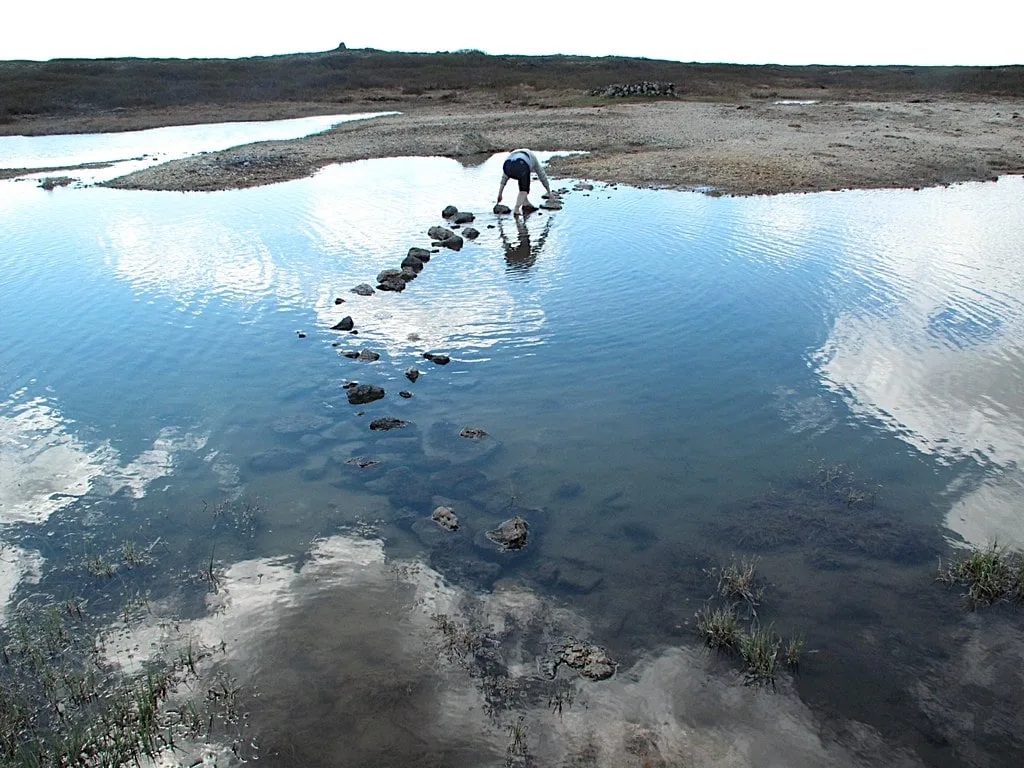Visitors have to cross the pond to reach Landbrotalaug hot pot
