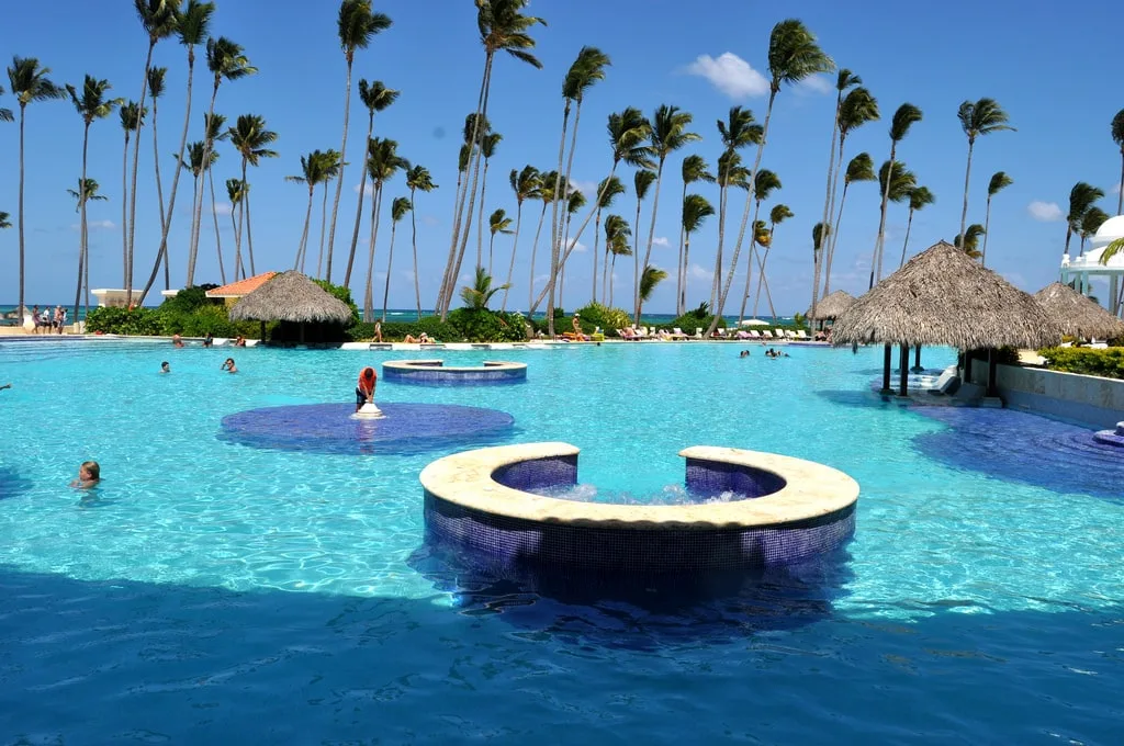 Pool surrounded by palm trees located in beach front at Grand Palladium Punta Cana