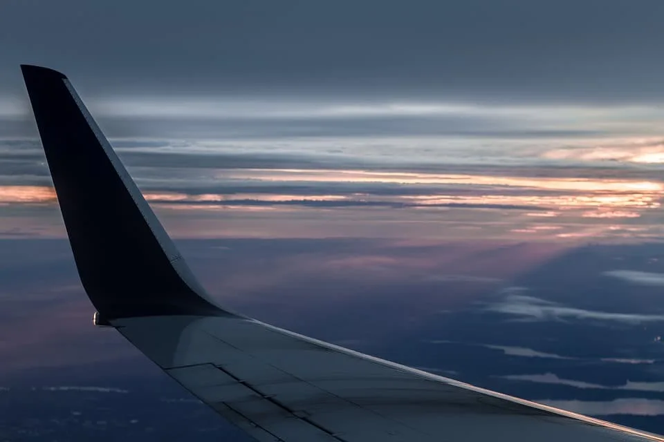 A Wing of a Flying Aeroplane During Sunset