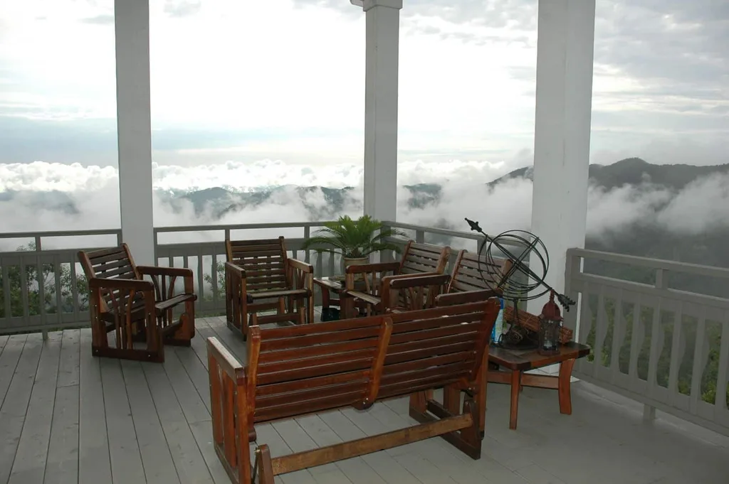 Benches on the verandah of Gracehill Bed and Breakfast. This mountain verandah is surrounded by billowing white clouds.