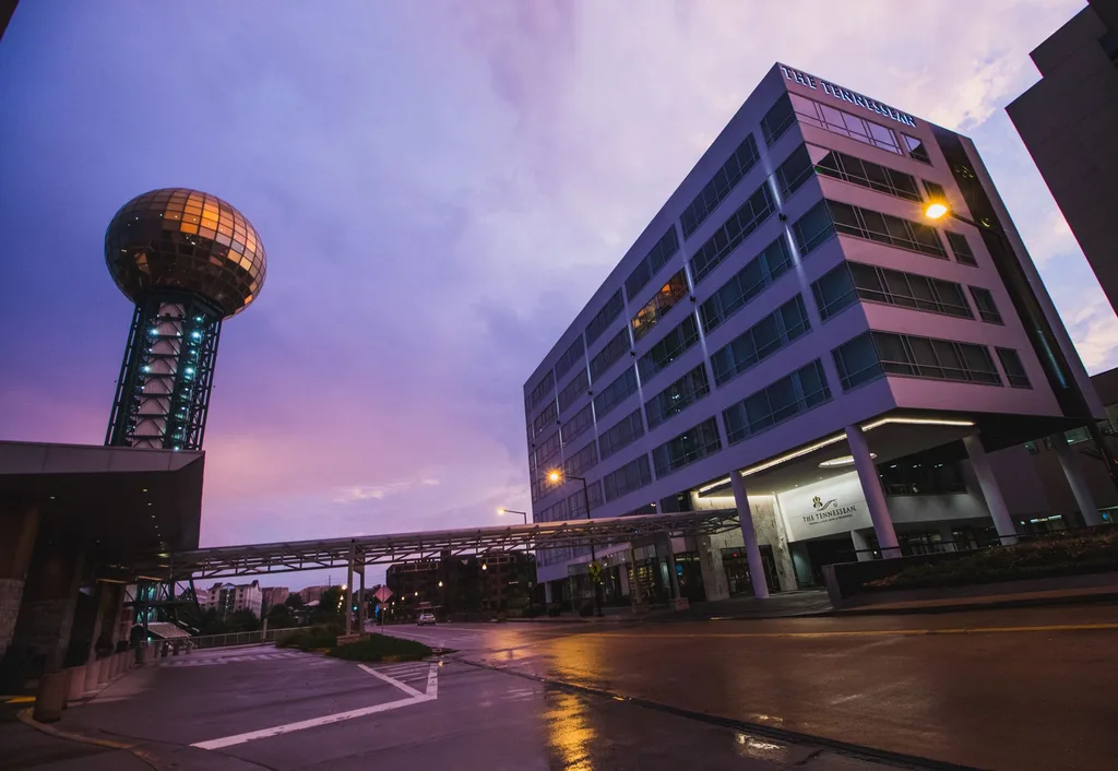 A front view of the Tennessean Hotel in the evening. It is located right next to the Knoxville Sunsphere Tower.